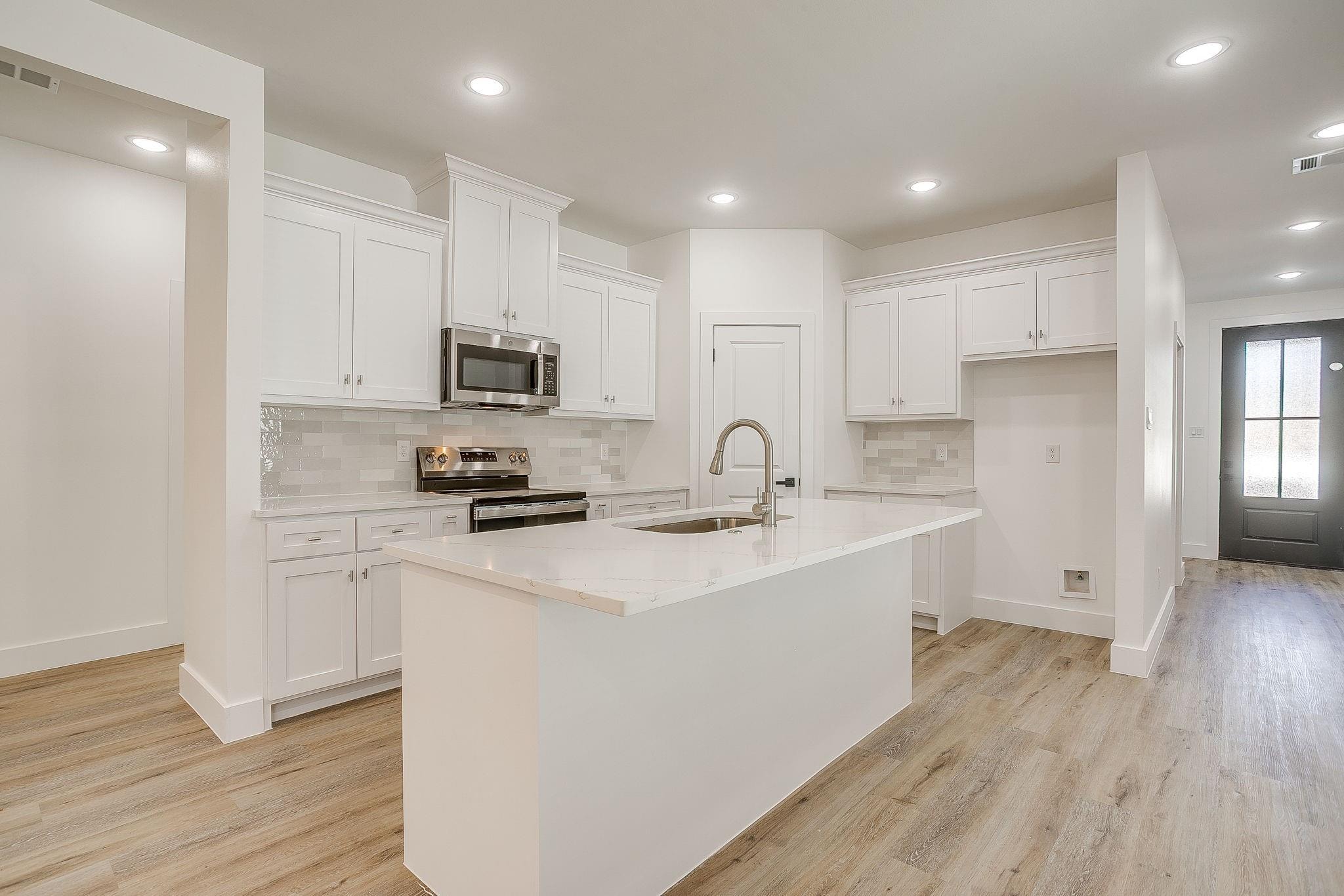 Dunbar Residence — kitchen with white cabinetry and stainless appliances